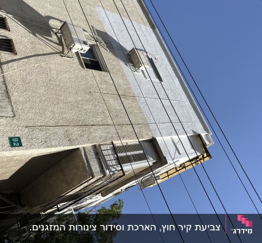 צביעה ושיפוץ קטע קיר בחזית בניין בגובה